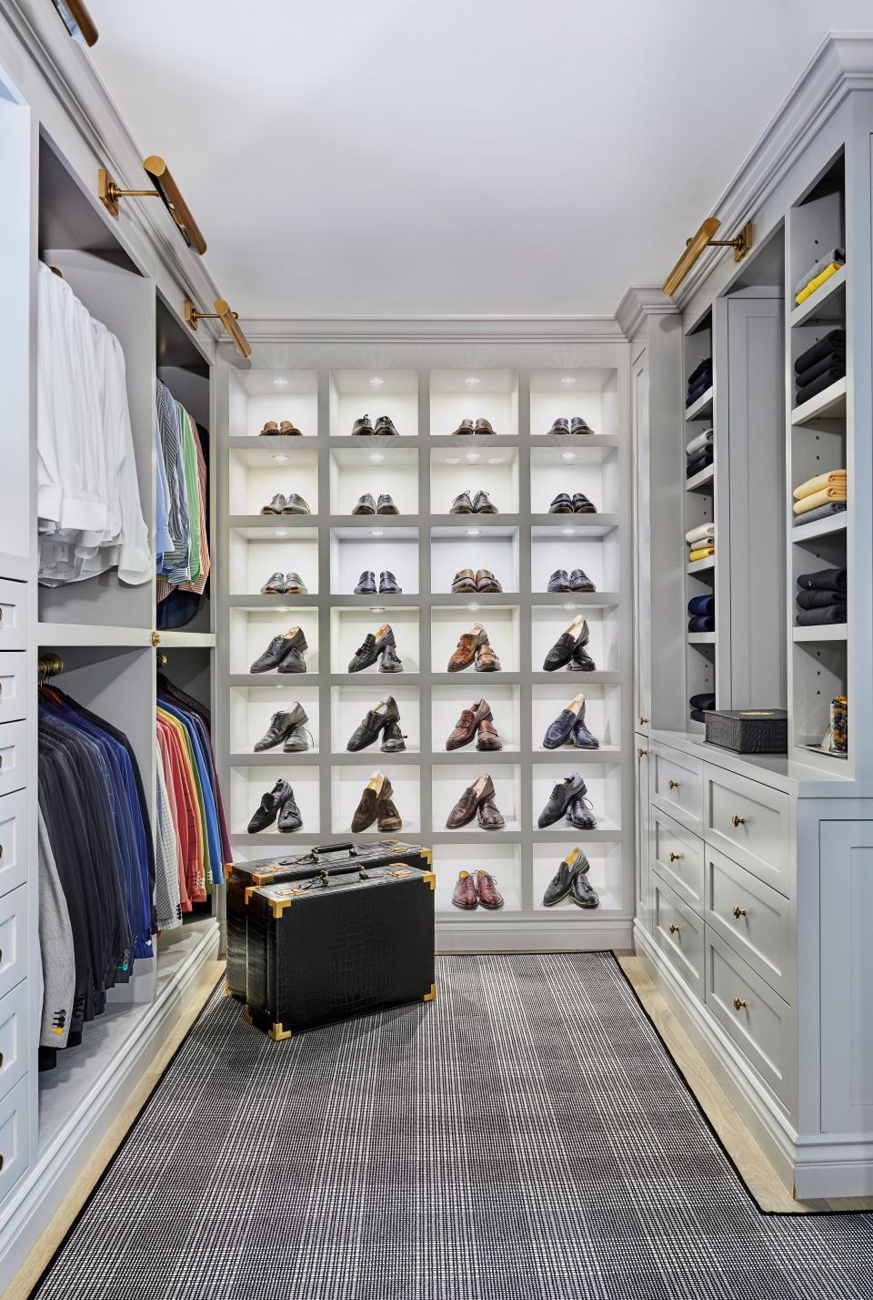 The “his” closet was a joke when the couple moved in, Nicolas recalls, prompting a serious remodel to house not only his wardrobe but extensive shoe collection. “The shoes were a big focal point and we wanted to really display them,” he says. “ I have to show it off, because the way it’s finished, with the lights and shoe cubbies, I think is really artistic.” House of Bijan crocodile luggage sits atop a Prince of Wales print rug by Stark.