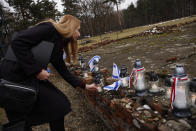 A woman places a candle at the former crematorium as they attend a ceremony in the former Nazi German concentration and extermination camp Auschwitz during ceremonies marking the 78th anniversary of the liberation of the camp in Brzezinka, Poland, Friday, Jan. 27, 2023. (AP Photo/Michal Dyjuk)