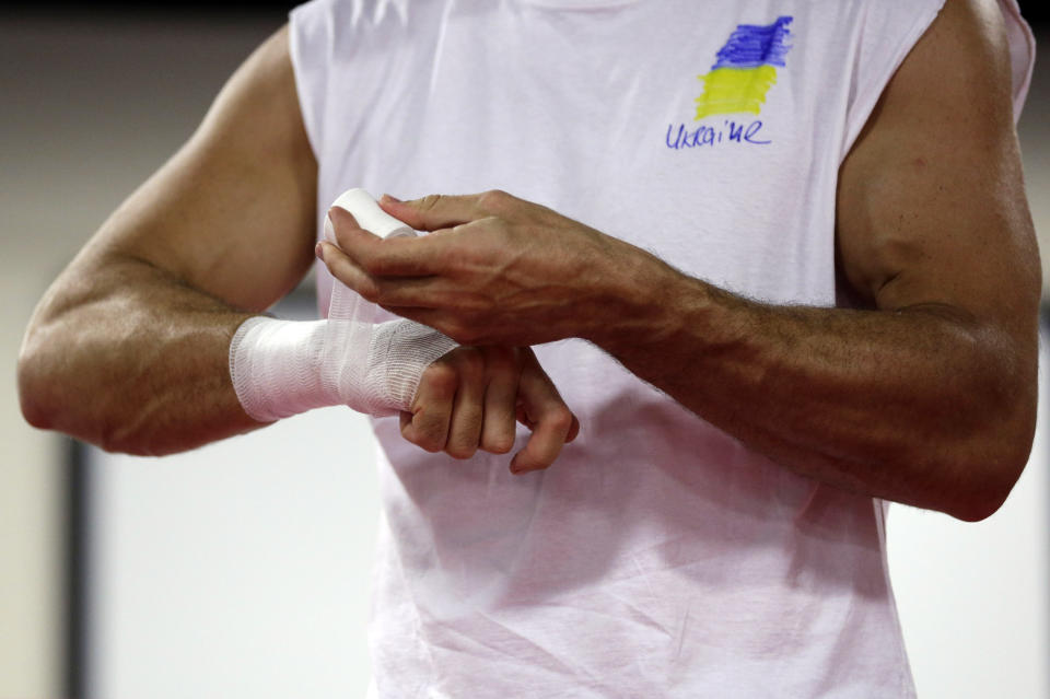 Heavyweight boxing champion Wladimir Klitschko, of Ukraine, tapes his hands while training at the Lucky Street Boxing Gym, Thursday, March 20, 2014, in Hollywood, Fla. Klitschko is preparing for his April 26 title fight against Alex Leapai in Germany. (AP Photo/Lynne Sladky)