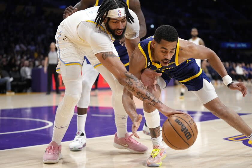 Los Angeles Lakers forward Anthony Davis, left, and Golden State Warriors guard Jordan Poole go after a rebound during the first half of an NBA basketball game Thursday, Feb. 23, 2023, in Los Angeles. (AP Photo/Mark J. Terrill)