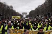 FILE - In this March 2, 2019 file photo, Yellow Vests protesters march on the Champs Elysees avenue in Paris. France's yellow vest protesters remain a force to be reckoned with five months after their movement started, and as President Emmanuel Macron announces his responses to their grievances. It includes people across political, regional, social and generational divides angry at economic injustice and the way President Emmanuel Macron is running France. (AP Photo/Kamil Zihnioglu, File)