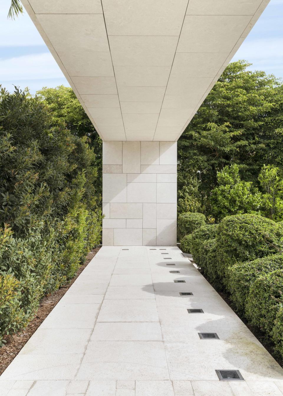 A green-walled garden with a limestone walkway.