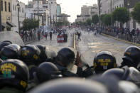 Anti-government protesters clash with police in Lima, Peru, Tuesday, Jan. 24, 2023. Protesters are seeking the resignation of President Dina Boluarte, the release from prison of ousted President Pedro Castillo, immediate elections and justice for demonstrators killed in clashes with police. (AP Photo/Martin Mejia)