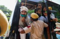 A policeman pushes Congress Party activists into a bus after detaining them during an anti-government demonstration to protest against the recent passing of new farm bills in parliament in New Delhi on September 28, 2020. (Photo by Sajjad HUSSAIN / AFP) (Photo by SAJJAD HUSSAIN/AFP via Getty Images)