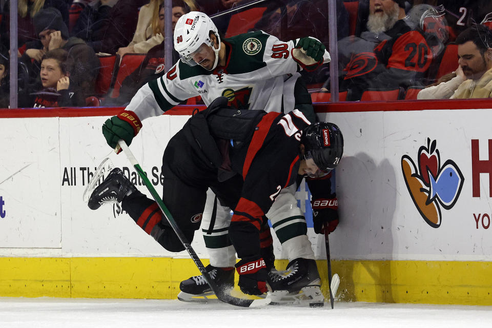 Minnesota Wild's Marcus Johansson (90) collides with Carolina Hurricanes' Seth Jarvis (24) during the first period of an NHL hockey game in Raleigh, N.C., Sunday, Jan. 21, 2024. (AP Photo/Karl B DeBlaker)