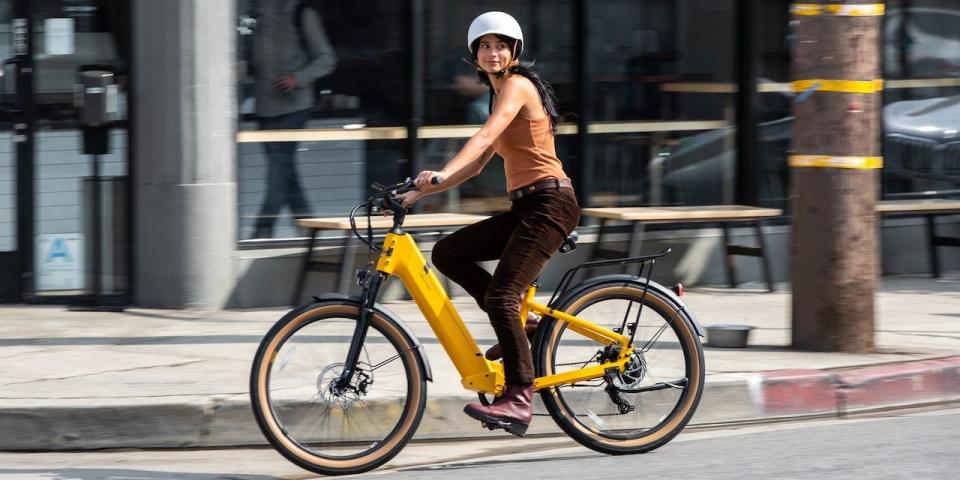 A woman rides a Velotric Discover e-bike.
