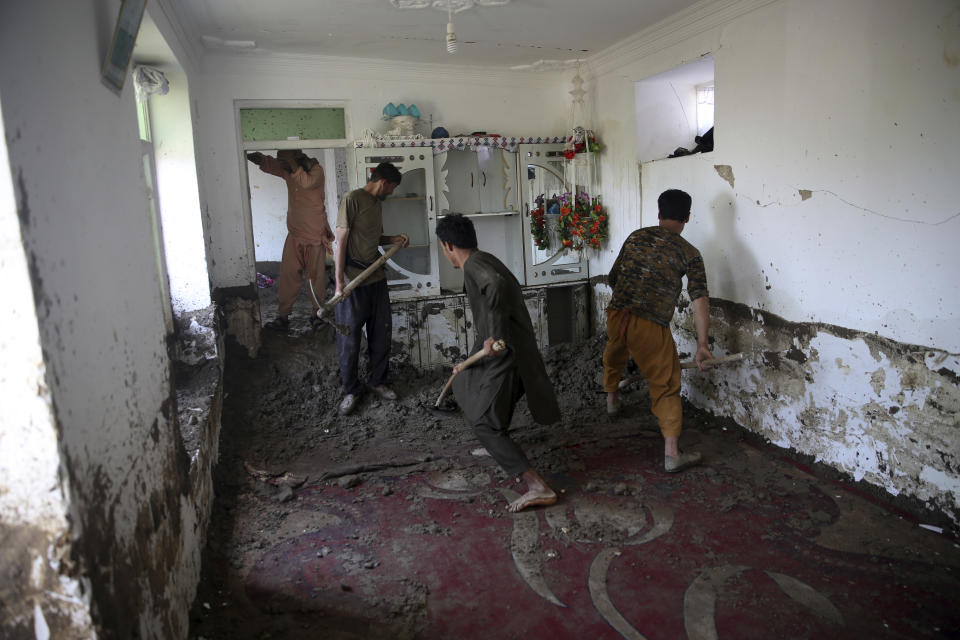 Afghans remove mud from inside their house after a mudslide caused by heavy flooding in the Parwan province, north of Kabul, Afghanistan, Thursday, Aug. 27, 2020. The death toll from heavy flooding in northern and eastern Afghanistan rose to at least 150 on Thursday, with scores more injured as rescue crews searched for survivors beneath the mud and rubble of collapsed houses, officials said. (AP Photo/Rahmat Gul)