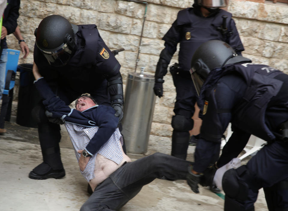 <p>Spanish police scuffle with a man outside a polling station for the banned independence referendum in Tarragona, Spain, Oct. 1, 2017. (Photo: David Gonzalez/Reuters) </p>