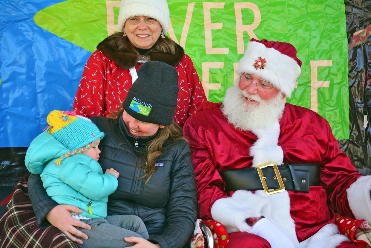 Amara Schulte, 2, with her mom Kristin Schulte, visit with Santa and Mrs. Claus as portrayed by Barney and Eileen Combs on Saturday at Cooper's Landing. The Combses volunteer with Missouri River Relief, of which Kristin Schulte is the nonprofit's education director, and had arranged a fundraiser for the nonprofit.
