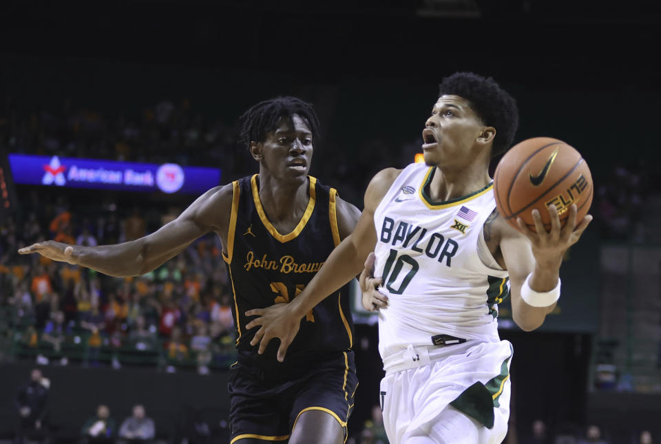 Baylor guard RayJ Dennis eyes the basket while driving past John Brown forward Tyren Collins in the first half of an NCAA college basketball game, Thursday, Nov. 9, 2023, in Waco, Texas. (AP Photo/Rod Aydelotte)