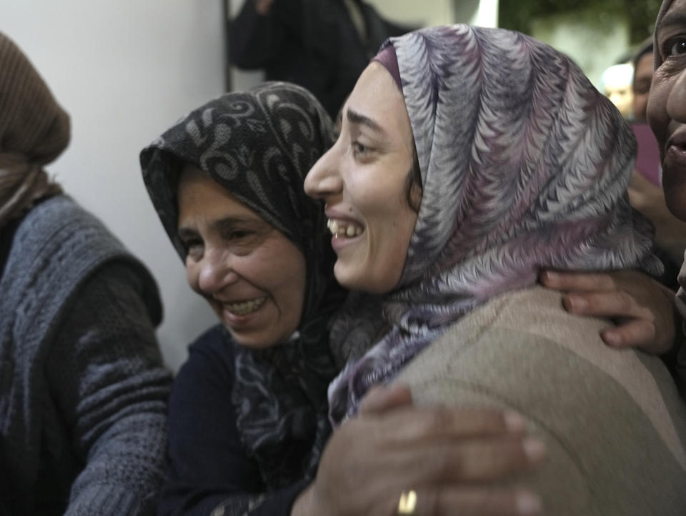 Shuruq Dwayat, right, a Palestinian prisoner released by Israel, is hugged by relatives as she arrives home in the east Jerusalem neighborhood of Sur Bahar, early Sunday Nov. 26, 2023. (AP Photo/Mahmoud Illean)