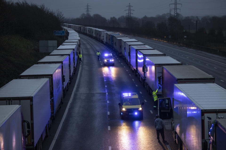 SELLINDGE, ENGLAND - DECEMBER 21: The coastguard give out bottles of water as lorries queue on the M20 on December 21, 2020 in Sellindge, England. Citing concern over a new covid-19 variant and England's surge in cases, France temporarily closed its border with the UK late Sunday, halting freight and ferry departures from the port of Dover for 48 hours. France also joined several other European countries in stopping rail and air travel from the UK. (Photo by Dan Kitwood/Getty Images)