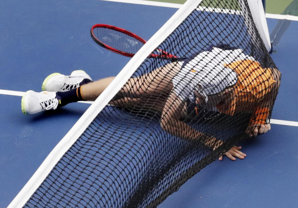 Denis Shapovalov, of Canada, falls into the net against Kevin Anderson, of South Africa, during the third round of the U.S. Open tennis tournament, Friday, Aug. 31, 2018, in New York. (AP Photo/Julio Cortez)