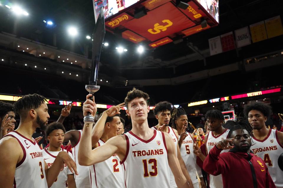 Southern California  guard Drew Peterson (13) holds a Trojans sword after the game against Washington.