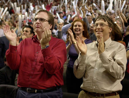 FILE PHOTO: Microsoft President Bill Gates (R) and Portland Trail Blazers owner Paul Allen (L) cheer from courtside in the final minutes as the Blazers play the Los Angeles Lakers in Game 3 of the NBA Western Conference Finals May 26, 2000. REUTERS/File Photo