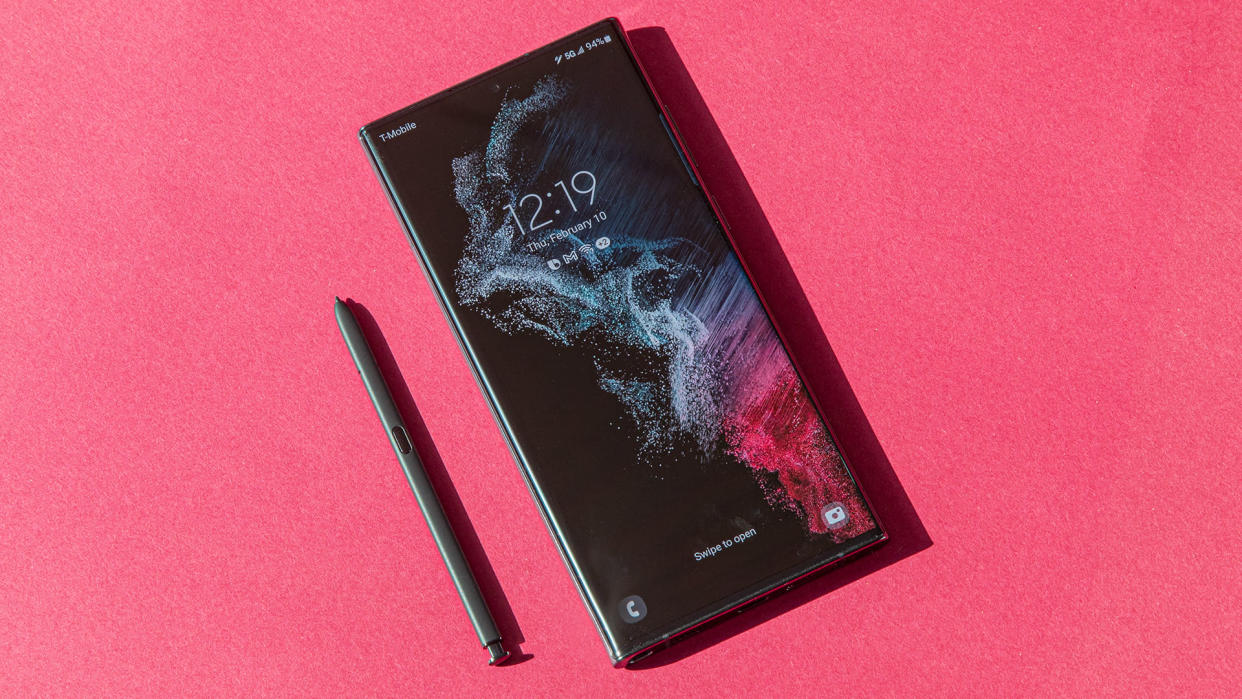 Samsung Galaxy S22 Ultra smartphone with stylus on a pink background.