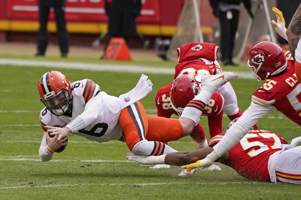 Cleveland Browns quarterback Baker Mayfield (6) dives for extra yardage ahead of Kansas City Chiefs defensive end Frank Clark, right, during the first half of an NFL divisional round football game, Sunday, Jan. 17, 2021, in Kansas City. (AP Photo/Charlie Riedel)