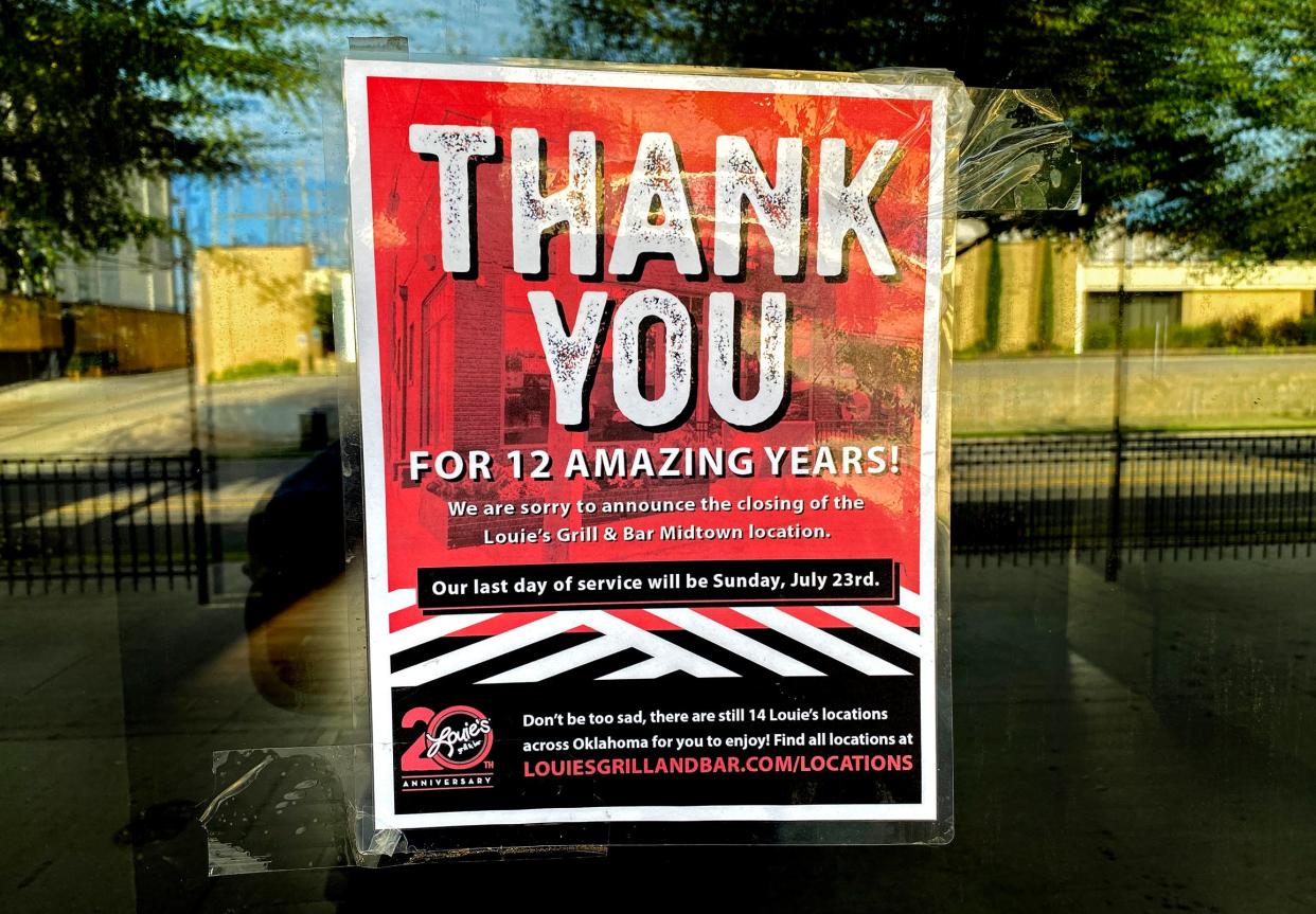 A sign hangs on the window of the former Louie's Grill and Bar in Midtown announcing its closure.