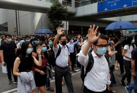 Anti-government office workers wearing masks attend a lunch time protest, after local media reported on an expected ban on face masks under emergency law, at Central, in Hong Kong