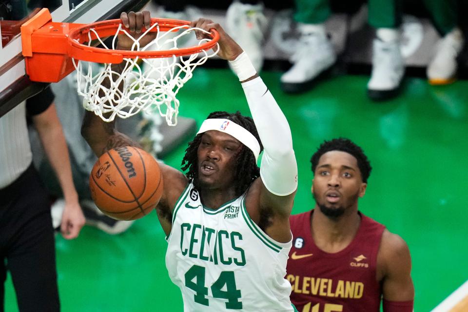 Boston Celtics center Robert Williams III (44) dunks against Cleveland Cavaliers guard Donovan Mitchell (45) during the first half of an NBA basketball game Wednesday, March 1, 2023, in Boston. (AP Photo/Charles Krupa)