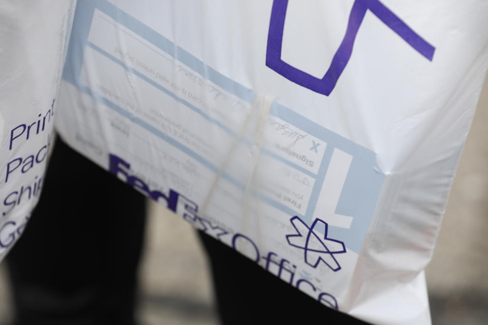 Julie Stewart, precinct captain in Waukee, Iowa, carries a bag of precinct preference cards back to her car after trying to drop them off at the Iowa Democratic Party headquarters, Tuesday, Feb. 4, 2020, in Des Moines, Iowa. (AP Photo/Charlie Neibergall)