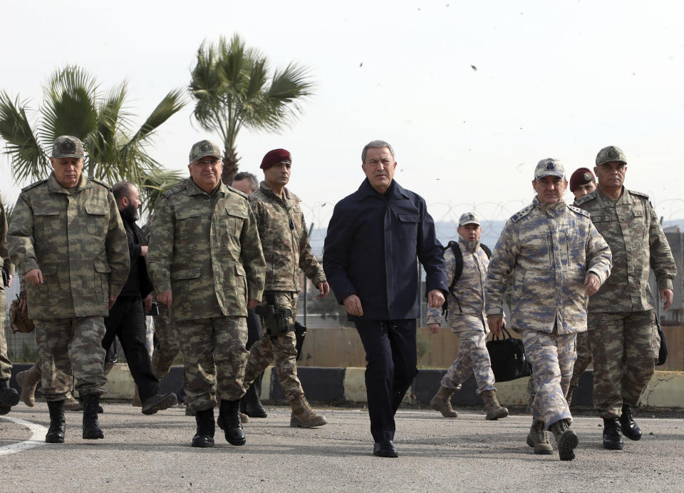 Turkey's National Defence Minister Hulusi Akar, center, and Turkish army's top commanders arrive to inspect troops at the border with Syria, in Hatay, Turkey, Monday, Feb. 3, 2020. Turkey hit targets in northern Syria, responding to shelling by Syrian government forces that killed at least eight Turkish military personnel, Turkish President Recep Tayyip Erdogan said Monday. A Syrian war monitor said 13 Syrian troops were also killed.(Turkish Defence Ministry via AP, Pool)