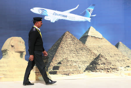 A police officer walks in front of a poster presenting an Egyptian plane at the new Sphinx International Airport in west Cairo, Egypt January 26, 2019. REUTERS/Mohamed Abd El Ghany