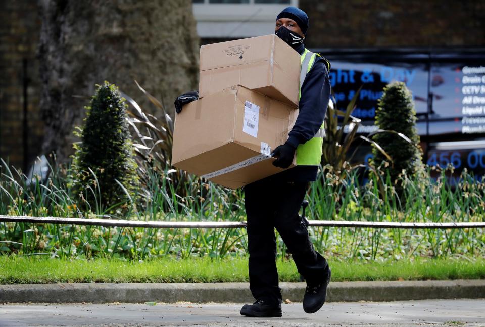 A Hermes delivery courier carries boxes as he makes a delivery to 10 Downing Street, the official residence of Britain's Prime Minister, in central London on May 5, 2020. - Britain's Prime Minister Boris Johnson's fiancee, Carrie Symonds, announced on May 2 that they had named their newborn son after their grandfathers and the hospital doctors who treated the British prime minister for COVID-19. The couple are the first unmarried couple to officially live together in Downing Street and the baby is the third to be born to a serving British prime minister in recent history. (Photo by Tolga AKMEN / AFP) (Photo by TOLGA AKMEN/AFP via Getty Images)