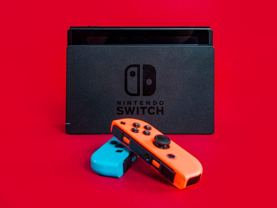 The Nintendo switch charging dock with two joycons resting in front of it