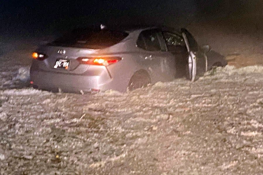 This image provided by JJ Unger, shows hail surrounding a vehicle, Monday night, May 20, 2024, in Yuma, Colo. Residents in the small city in northeastern Colorado were cleaning up Tuesday after hail the size of baseballs and golf balls pounded the community, with heavy construction equipment and snow shovels being used to clear hail that had piled up knee-deep the night before. (JJ Unger via AP)