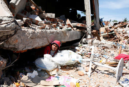 A man retrieves fans from a collapsed shop following a strong earthquake in Meureudu, Pidie Jaya, Aceh province, Indonesia. REUTERS/Darren Whiteside