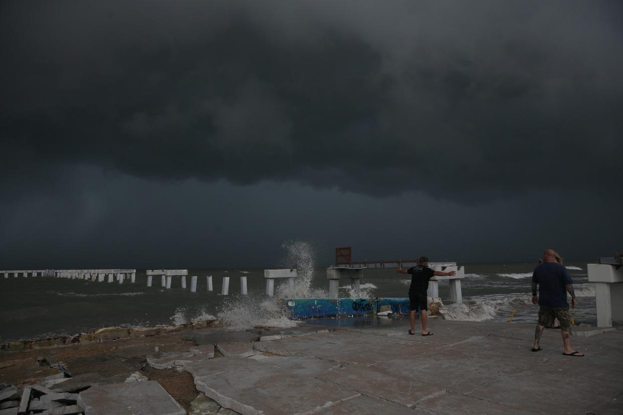 Beachgoers check out the surf as Hurricane Idalia approaches Florida at Times Square on Fort Myers Beach on Tuesday, Aug. 29, 2023.