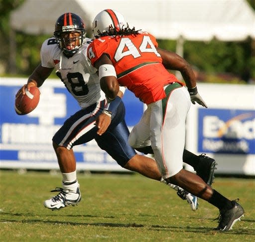 Virginia quarterback Marques Hagans, left, scrambles away from Miami linebacker Leon Williams.