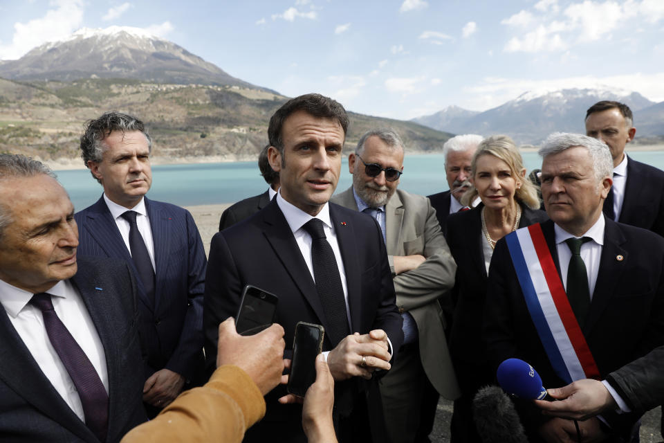 French President Emmanuel Macron, center, speaks to journalists upon his arrival in Sainte-Savine-Le-Lac, southeastern France, Thursday, March 30, 2023. Emmanuel Macron presented a plan for saving France's water after exceptional winter drought, February wildfires and violence between protesters and police over an agricultural reservoir. (Sebastien Nogier, Pool via AP)