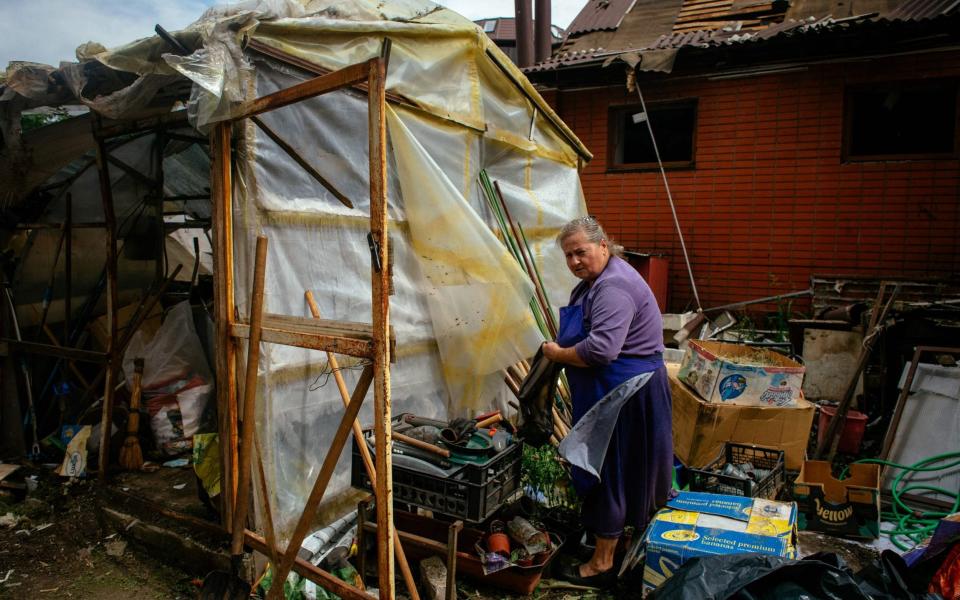 An elderly woman collects her belongings following a missile strike on the second-largest Ukrainian city of Kharkiv  - AFP