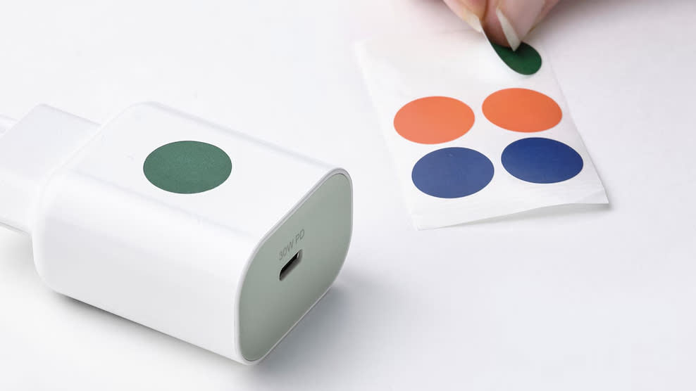  An IKEA fast charger on a table next to colored stickers. 