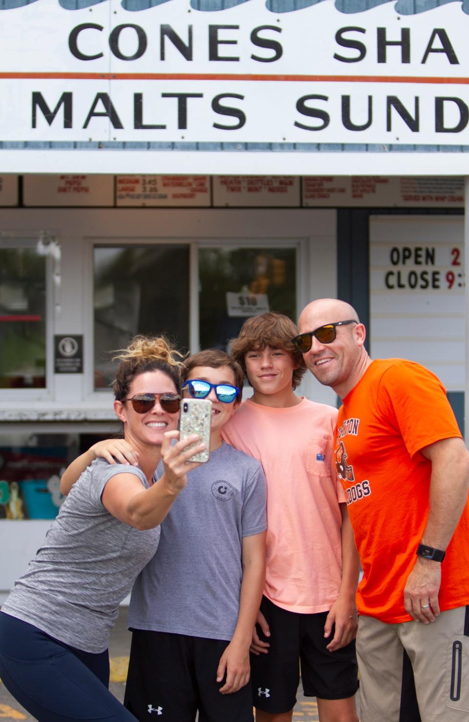 Brandi and Jeff Buckley and their two boys 11-year-old Weston (left) and Owen, 14, of Brighton take a selfie in front of Hamburg Township's Cap'n Frosty ice cream shop Friday, July 2, 2021 as they await being called up for their order.