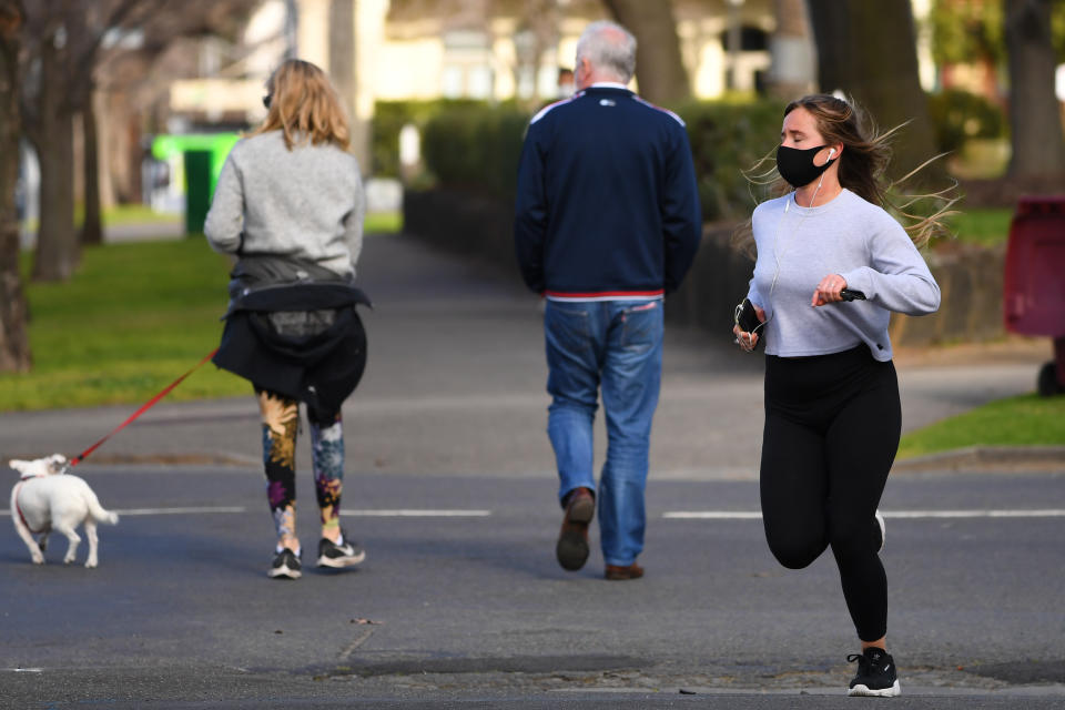 A woman jogs while wearing a mask in Melbourne on Monday. Source: AAP