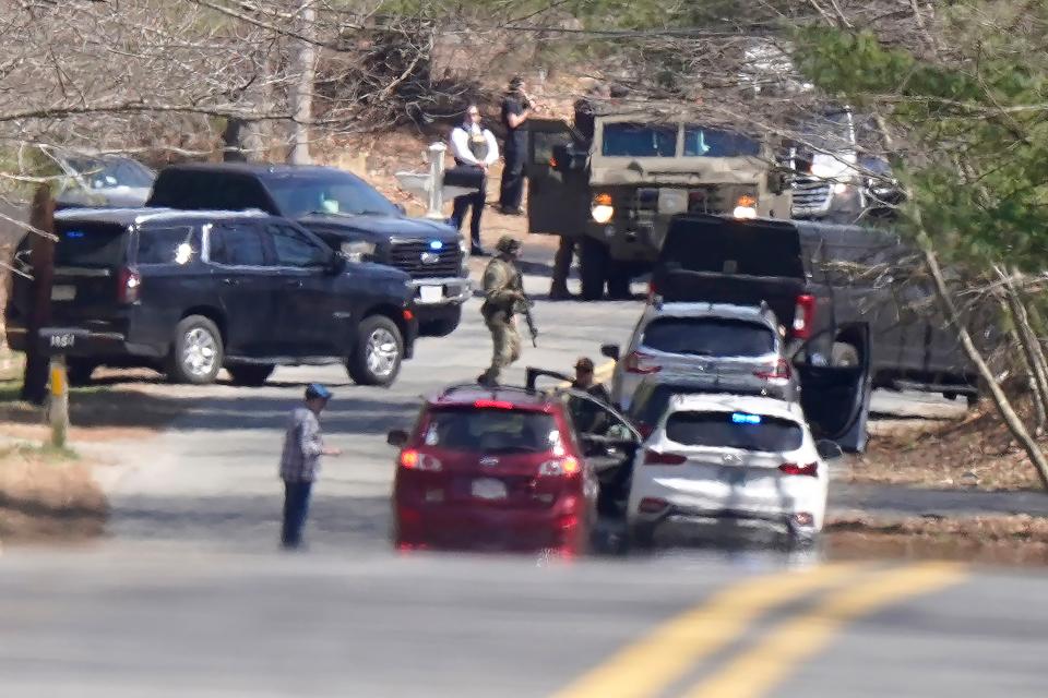 Members of law enforcement assemble on a road, Thursday, April 13, 2023, in Dighton, Mass., near where FBI agents converged on the home of a Massachusetts Air National Guard member who has emerged as a main person of interest in the disclosure of highly classified military documents on the Ukraine. (AP Photo/Steven Senne)