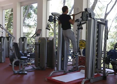 Russian Prime Minister Dmitry Medvedev performs a pull-up during a gym exercise session at the Bocharov Ruchei state residence in Sochi, Russia, August 30, 2015. REUTERS/Yekaterina Shtukina/RIA Novosti/Pool