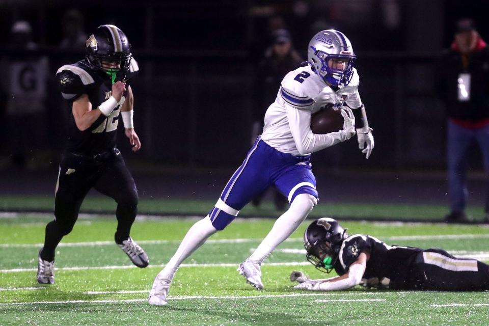 Olentangy Liberty's Alex Okuley breaks away from Perrysburg's Joseph Seney (32) and AJ Bernthisel (22) during an OHSAA Division I Semifinal game Nov. 11 in Fostoria.