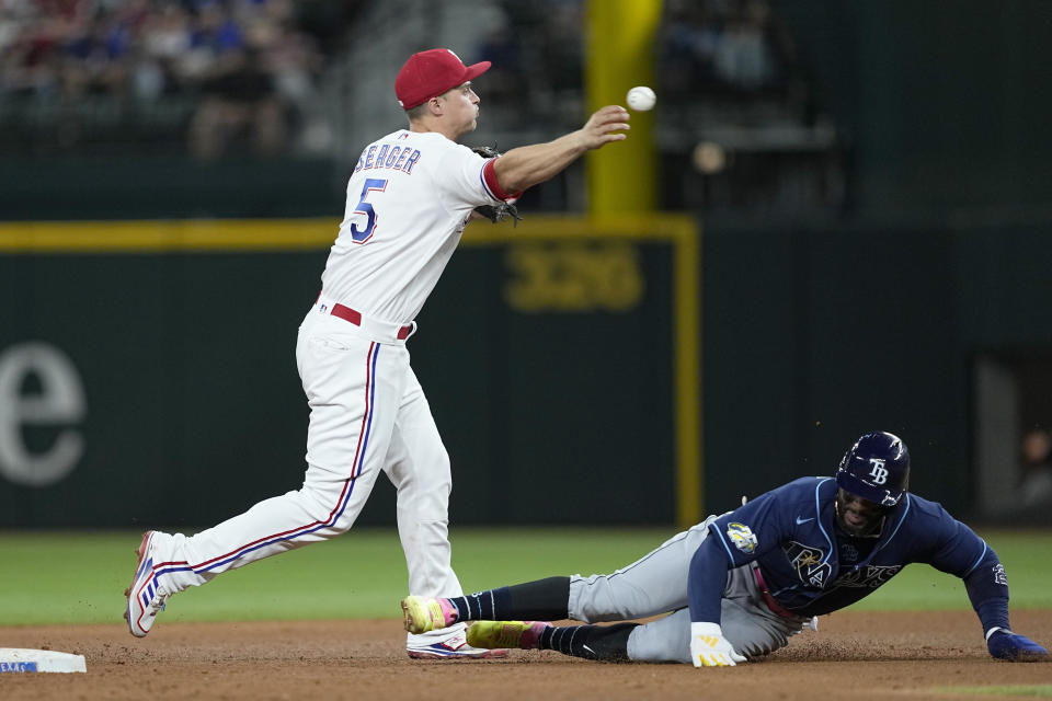 Texas Rangers shortstop Corey Seager throws to first to complete the double play after forcing out Tampa Bay Rays' Yandy Diaz at second during the seventh inning of a baseball game Tuesday, July 18, 2023, in Arlington, Texas. Wander Franco was out at first. (AP Photo/Tony Gutierrez)