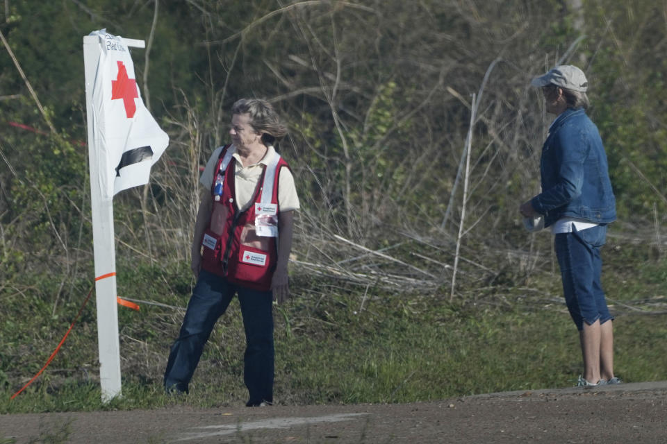 American Red Cross volunteers admire their handiwork after fighting through a stiff wind to succeed in taping down a directional sign for those Silver City, Miss., residents affected by Friday's tornado and needing assistance, Tuesday, March 28, 2023. (AP Photo/Rogelio V. Solis)