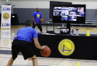 In this photo taken on Tuesday, June 9, 2020, coach Jose Rivera goes through a drill with his virtual students at Golden State Warriors basketball camp in Oakland, Calif. The Warriors had to adapt their popular youth basketball camps and make them virtual given the COVID-19 pandemic. (AP Photo/Ben Margot)