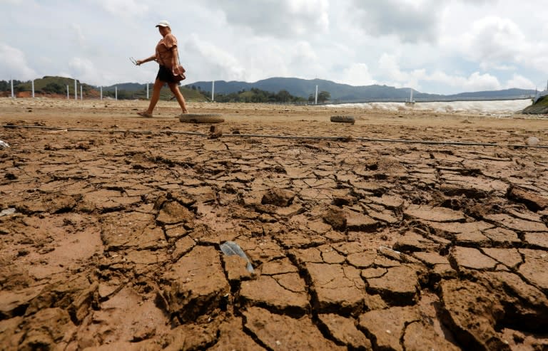 Una mujer camina por el embalse de El Peñol-Guatape, con el antiguo lecho reseco, el 12 de marzo de 2024 en la localidad colombiana de Guatape, a 62 km de la ciudad de Medellín (Jaime Saldarriaga)