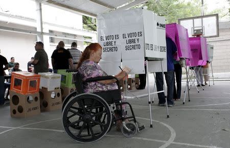 A woman in a wheelchair casts her ballot during mid-term elections in the town of Santiago, state of Nuevo Leon, June 7, 2015. REUTERS/Daniel Becerril