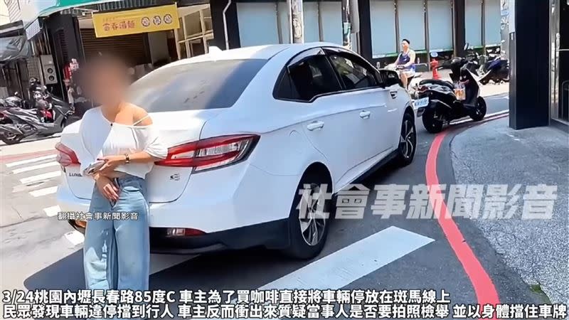 白衣婦人用肉身擋住車牌，不給民眾拍攝檢舉。（圖／翻攝自社會事新聞影音）