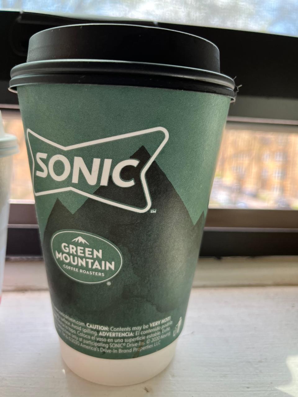 cup of sonic coffee sitting on a window ledge