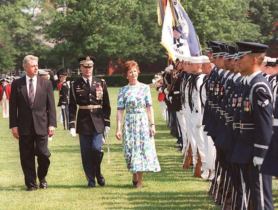 US President Bill Clinton and Irish President Mary Robinson walk alongside a US military honor guard with US Army Major General Robert Foley at Fort Myer, Virginia, in June 1996 (AFP via Getty Images)