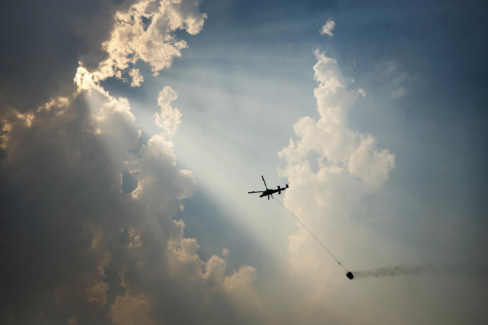 A helicopter carries a water bucket while battling the McKinney Fire, Tuesday, Aug. 2, 2022, in Klamath National Forest, Calif. (AP Photo/Noah Berger)